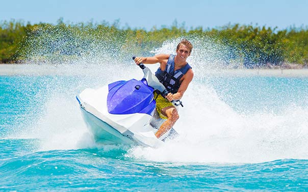 A couple riding a dark blue watercraft in the ocean